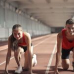 Lifesaving Skills - Men and Woman in Red Tank Top is Ready to Run on Track Field