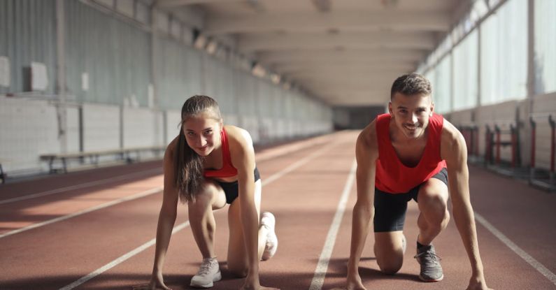 Lifesaving Skills - Men and Woman in Red Tank Top is Ready to Run on Track Field