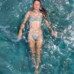 Seasonal Pool Closing - From above of young woman in bikini floating on azure calm sea water while enjoying vacation on resort