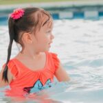 Pool Filtration - A little girl in an orange swimsuit in a pool