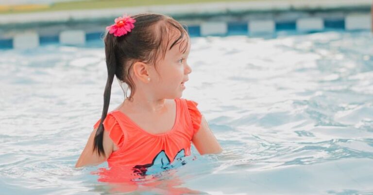 Pool Filtration - A little girl in an orange swimsuit in a pool