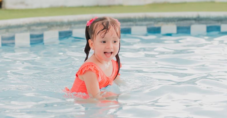 Pool Alarms - A little girl in an orange swimsuit in a pool
