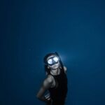 Night Swimming - Unrecognizable woman diving in blue sea water