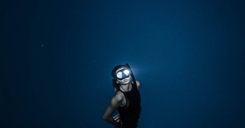 Night Swimming - Unrecognizable woman diving in blue sea water