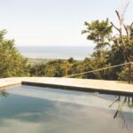 Pool Rules - A pool with a view of the ocean and trees