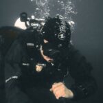 Underwater-Themed Bash - A scuba diver is holding a camera underwater