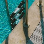 Shock Your Pool - A pool with a metal ladder and a shadow