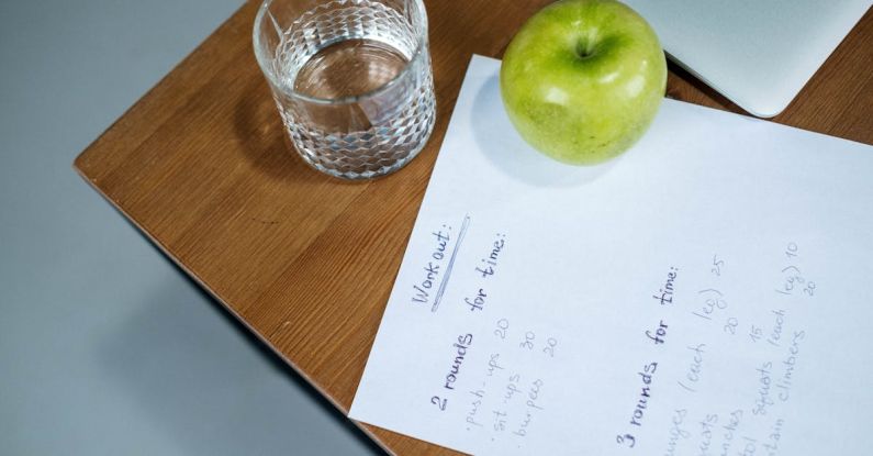 Workout Plan - Green Apple and Glass of Water on the Wooden Table