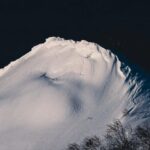 Winterizing - A snow covered mountain with trees in the background