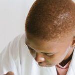 Video Analysis - Focused African American technical worker replacing faulty elements on video card