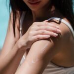 Water-Resistant Sunscreens - From above of female wearing sunglasses and bikini relaxing on deckchair on poolside at resort